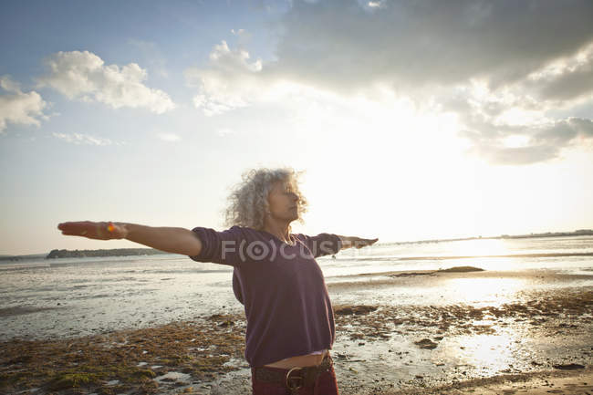 Femme mature faisant de l'exercice sur la plage — Photo de stock
