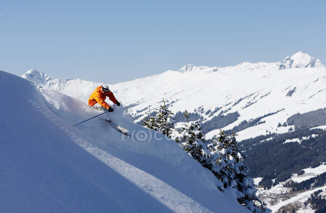 Людина катається на лижах вниз по схилу — стокове фото