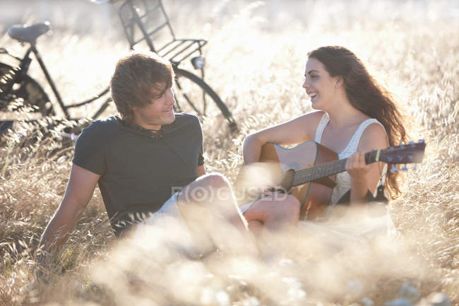 Woman playing guitar for boyfriend — Stock Photo