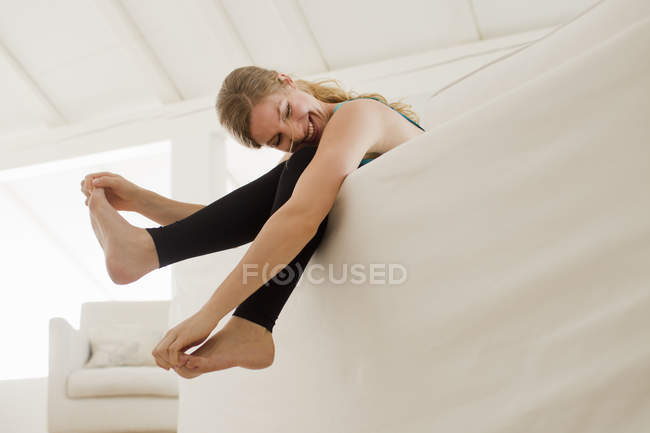 Женщина висит ногами над диваном — стоковое фото