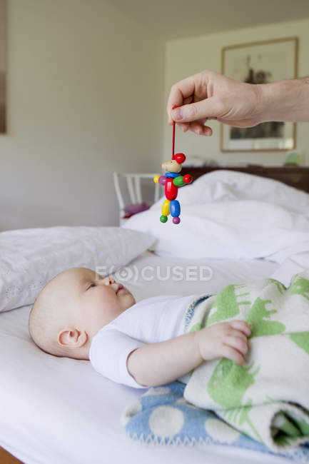 Father holding wooden toy for baby daughter — Stock Photo