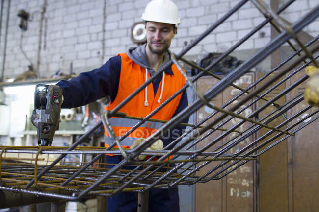 Fabrikarbeiter befestigt Stahlgitter an Betonbewehrungsfabrik — Stockfoto