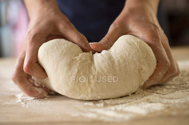 Primo piano di mani impastando la pasta di pane — Foto stock