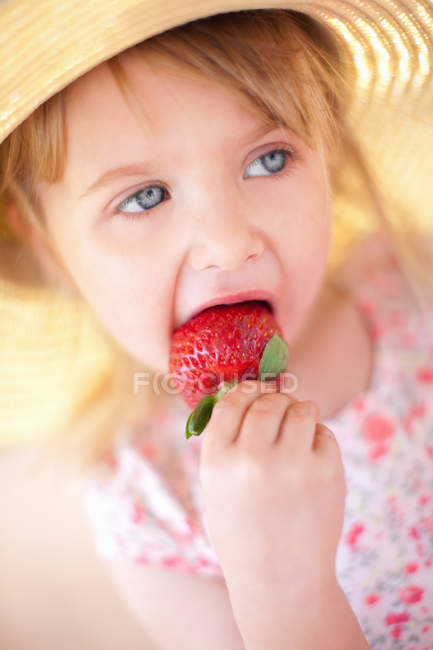 Nahaufnahme eines Mädchens, das Erdbeere isst — Stockfoto