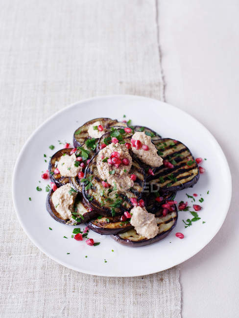 Eggplant salad with pomegranate seeds served on plate — Stock Photo