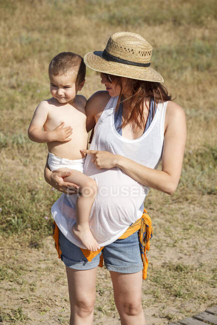 Madre sosteniendo hijo en brazos - foto de stock