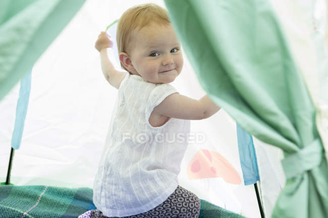 Baby girl playing in tent — Stock Photo
