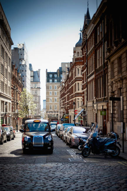 Taxi driving on cobbled London street — Stock Photo