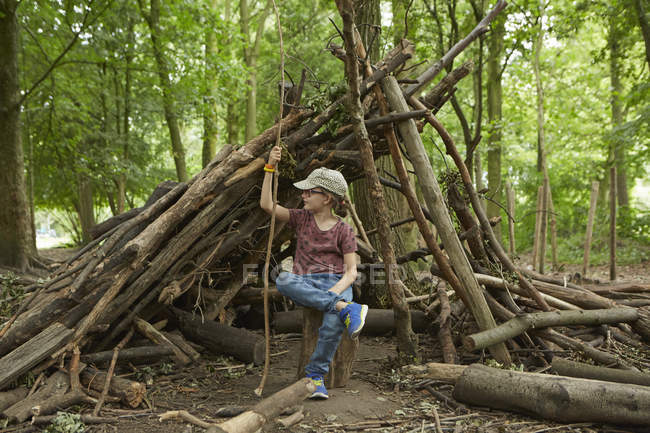 Menina sentada perto de log camp na floresta, Amsterdã, Holanda — Fotografia de Stock