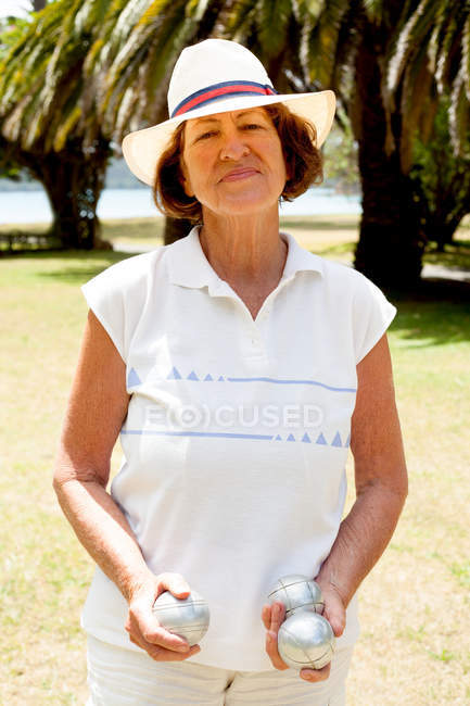 Porträt einer Seniorin mit Boule-Kugeln im Park — Stockfoto