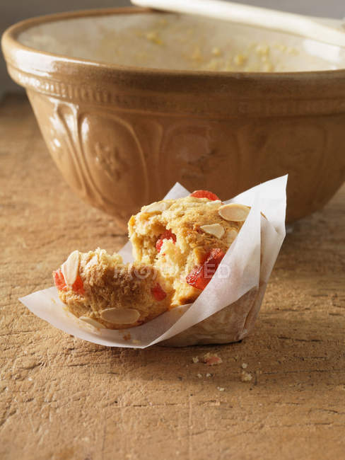 Broken cherry almond muffin in cake wrapper — Stock Photo