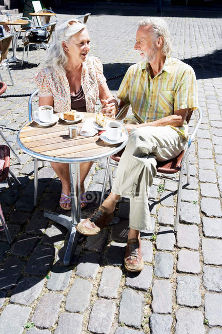 Couple sitting at cafe table — Stock Photo