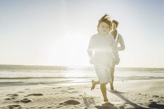 Отец и сын гуляют по пляжу — стоковое фото