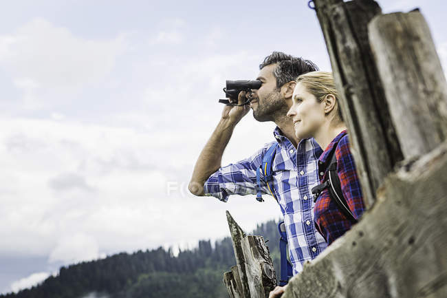 Primer plano de pareja disfrutando de la vista a través de prismáticos, Tirol, Austria - foto de stock