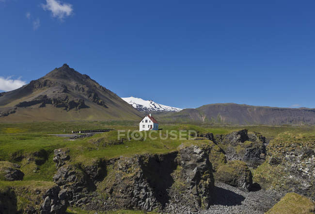 Cottage edificio su verdi colline paesaggio alla luce del sole — Foto stock