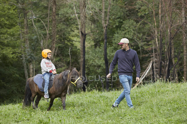 Отец с дочерью верхом на пони, Валье-де-Аран, Испания — стоковое фото