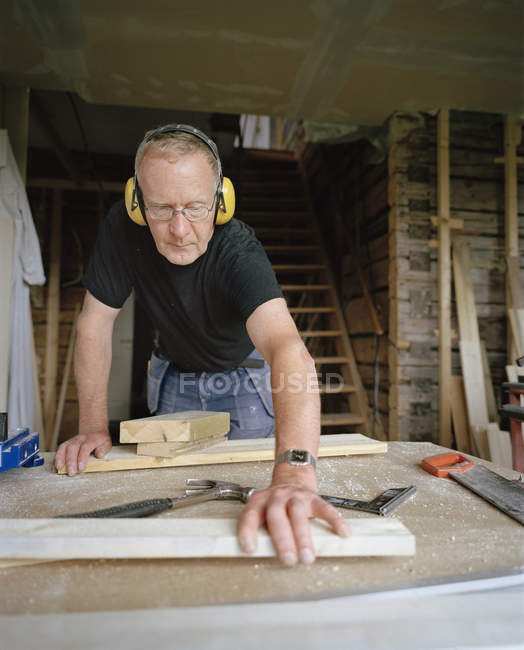 Homme âgé faisant de la menuiserie en atelier — Photo de stock