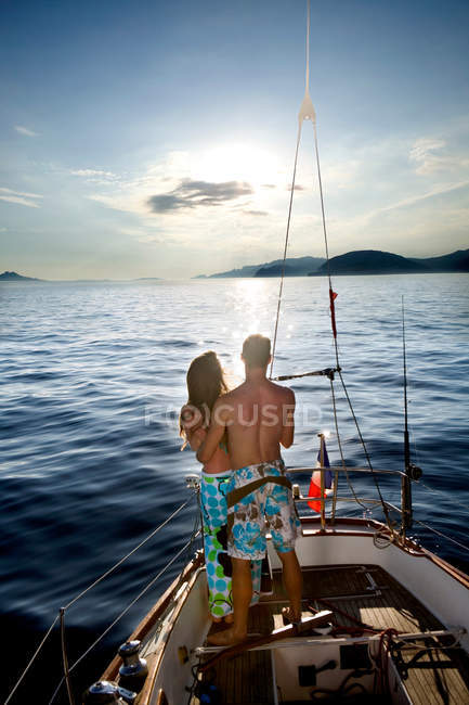 Giovane coppia in barca a vela guardando il tramonto — Foto stock