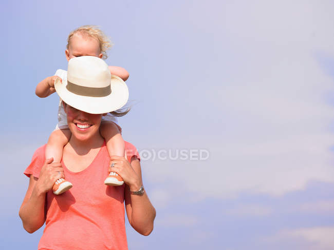 Woman carrying daughter on shoulders — Stock Photo