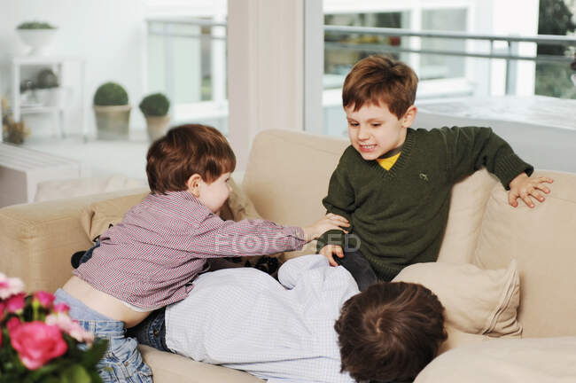 Chicos jugando en el sofá - foto de stock