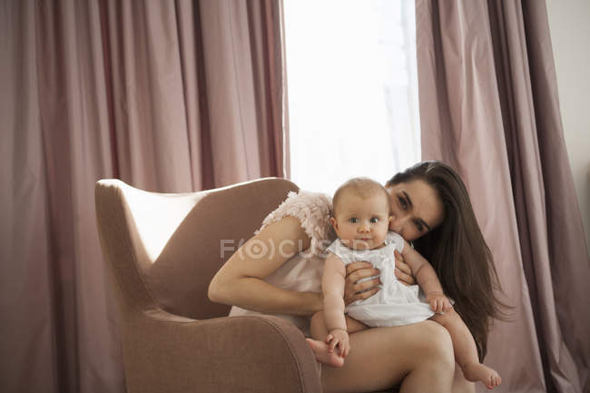 Mãe brincando com bebê em poltrona — Fotografia de Stock