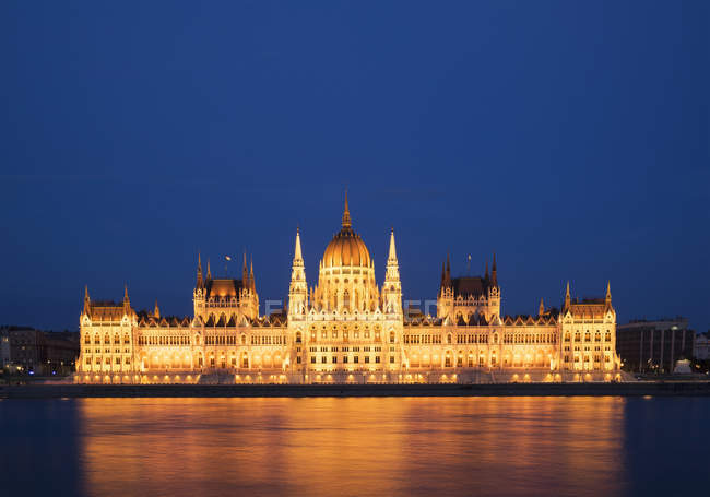 Vista frontal del Parlamento iluminado por la noche, Hungría, Budapest - foto de stock