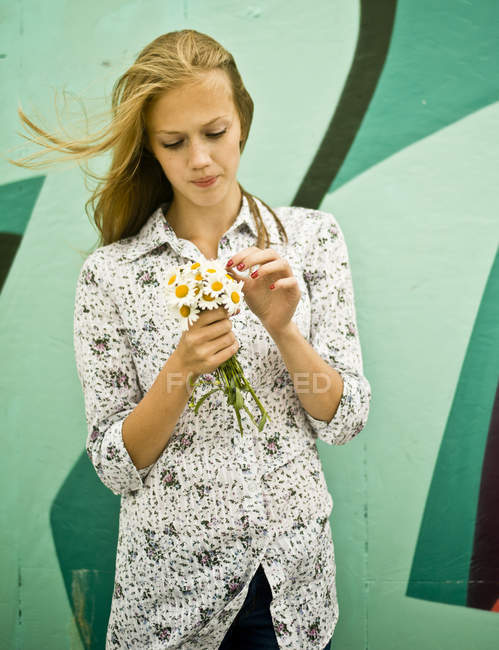 Portrait of young woman with bunch of daisies — Stock Photo