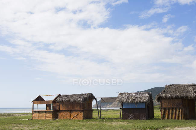 Cabanes dans une rangée par l'océan, Puerto Lopez, Équateur — Photo de stock