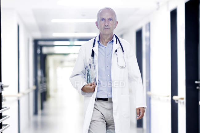 Médico varón caminando por el pasillo - foto de stock