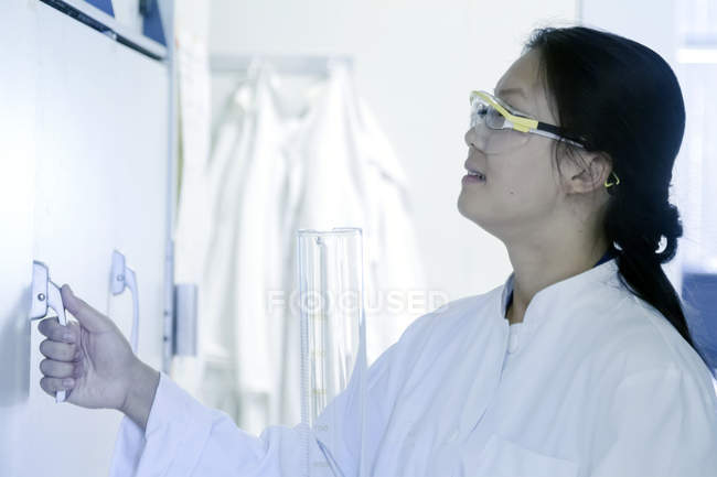 Armadio campione di apertura scienziata femminile in laboratorio — Foto stock