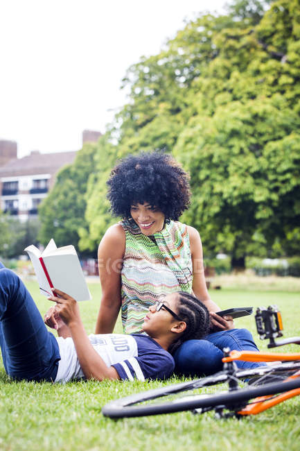 Boy and mother relaxing and reading in park — Stock Photo