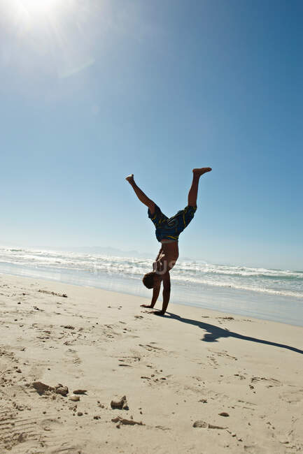 Young man doing hand stands — Stock Photo