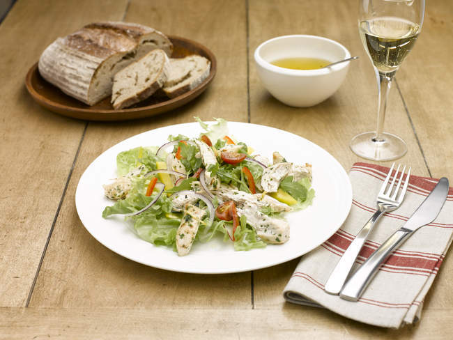 Salada de frango servida com talheres e taça de champanhe — Fotografia de Stock