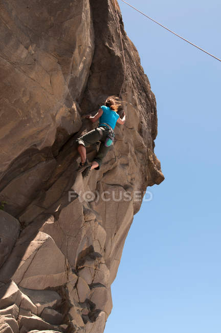 Rock climber scaling jagged cliff — Stock Photo