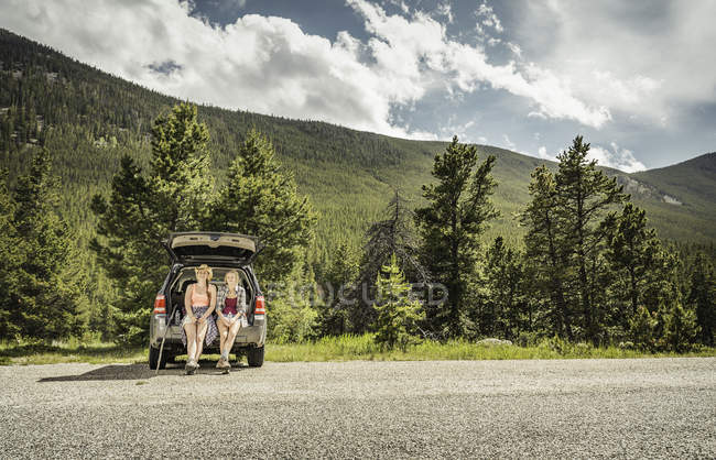 Молода жінка і Дівчинка-підліток мандрівного виглядає зі завантаження автомобіля, червоний Lodge, штат Монтана, США — стокове фото