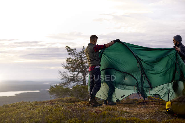 Hikers building tent on travel, Lapônia, Finlândia — Fotografia de Stock