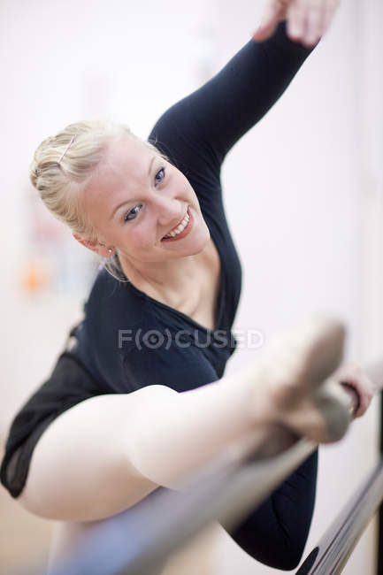 Femme ballerine étirement à barre — Photo de stock