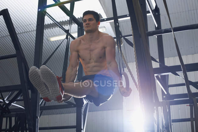 Mann trainiert an Turngeräten mit Gymnastikringen — Stockfoto