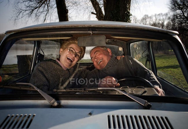 Coppia anziana ridendo in auto — Foto stock