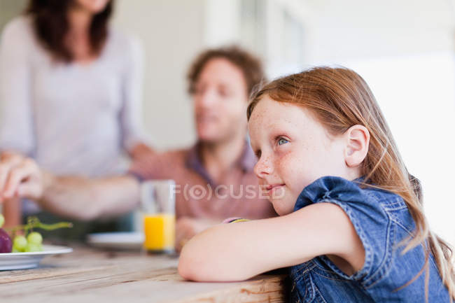 Menina sentada na mesa de café da manhã — Fotografia de Stock