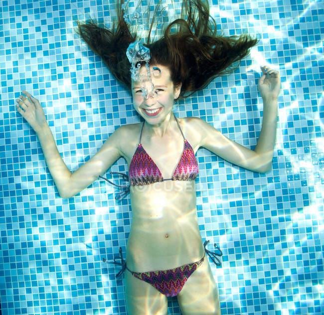 Sonriente Chica bajo el agua en la piscina - foto de stock