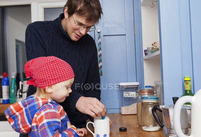 Отец делает чашку чая с сыном на кухне — стоковое фото