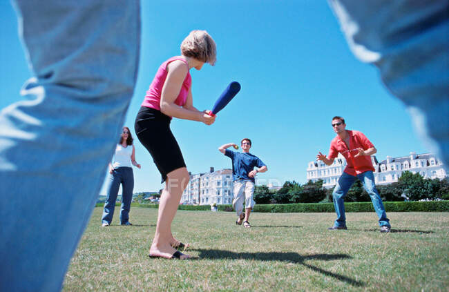 A group playing baseball in a park — Stock Photo