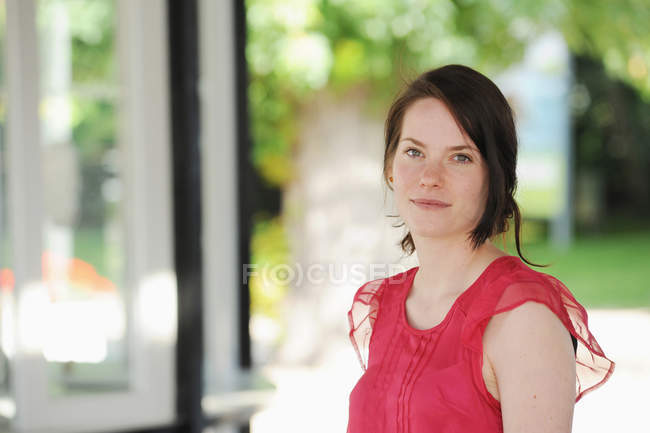 Smiling woman standing indoors — Stock Photo