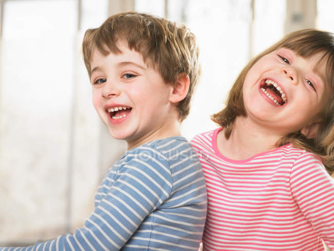 Kinder lächeln gemeinsam drinnen — Stockfoto