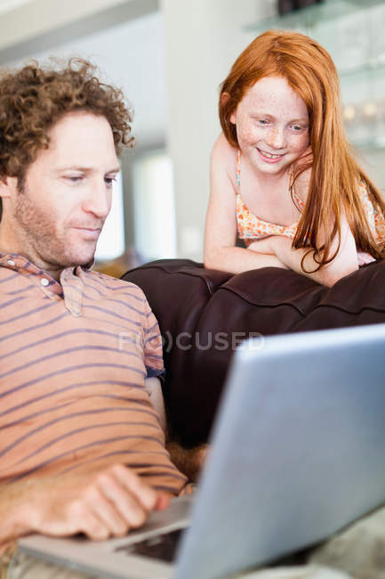 Padre e hija usando laptop - foto de stock