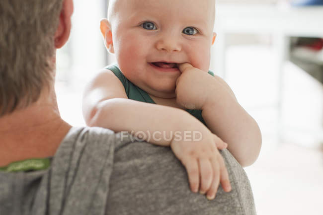 Retrato de pai carregando bebê filha com o dedo na boca — Fotografia de Stock
