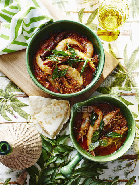 Portions of prawns with tomato sauce on table — Stock Photo