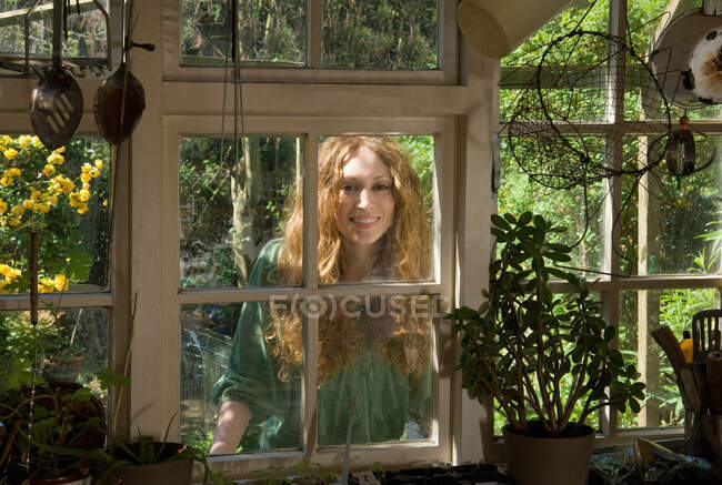 Frau blickt durch Küchenfenster — Stockfoto