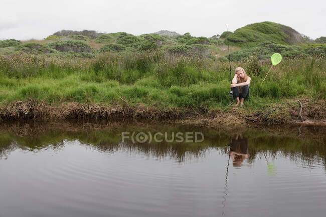 Chica de pesca con red en arroyo - foto de stock